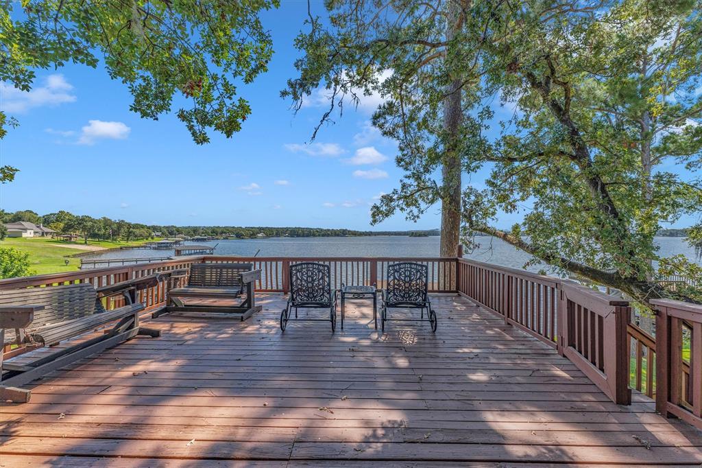 a view of a balcony with wooden floor and outdoor seating