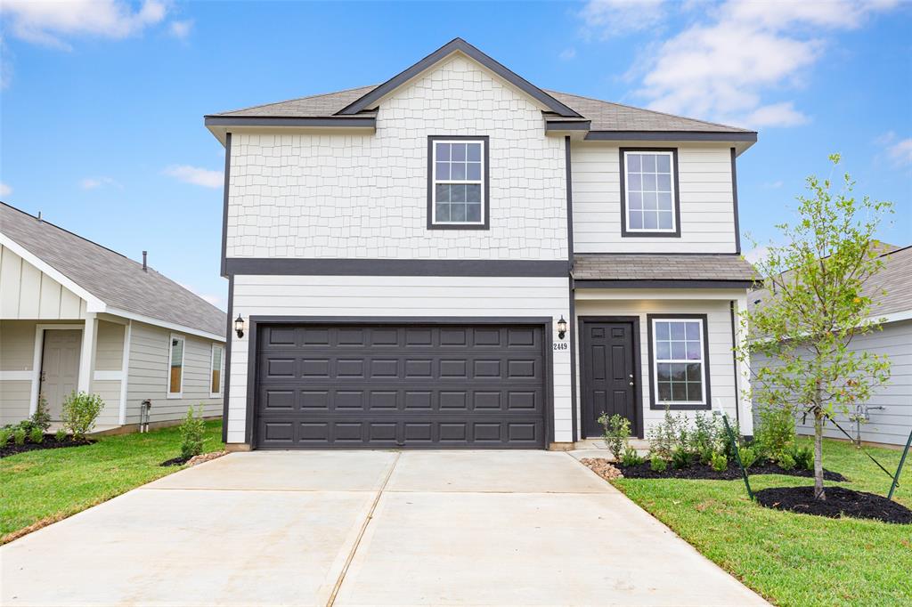 a front view of a house with a yard and garage