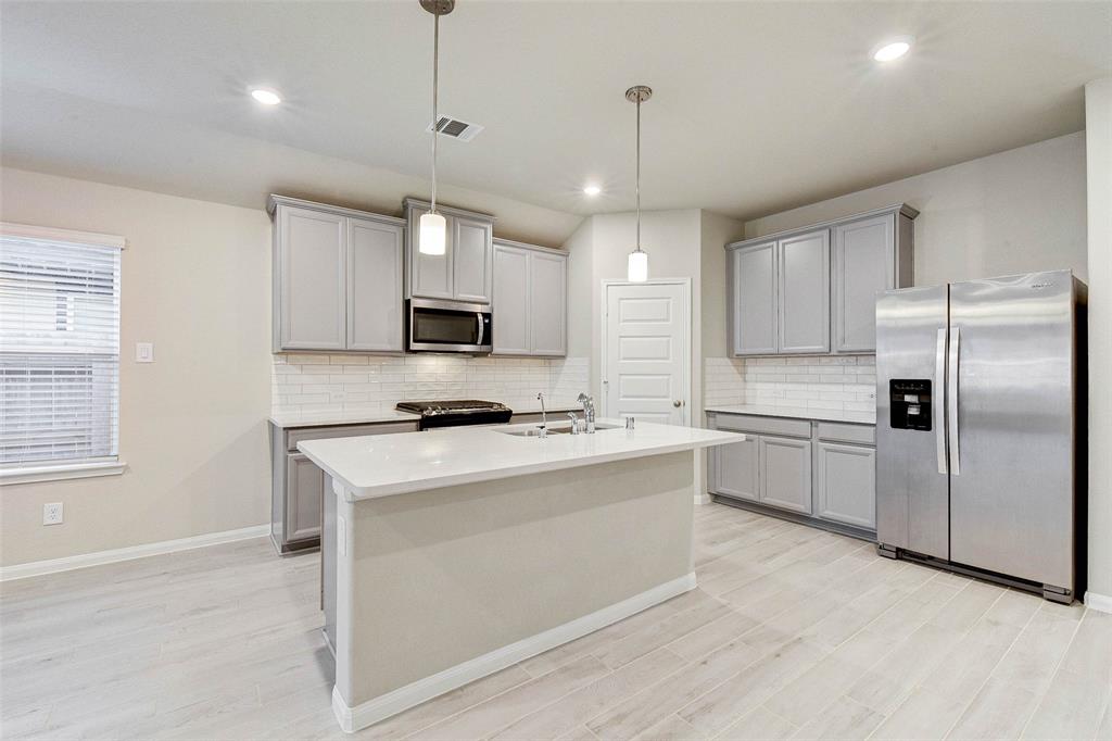 a kitchen with kitchen island a white cabinets and refrigerator