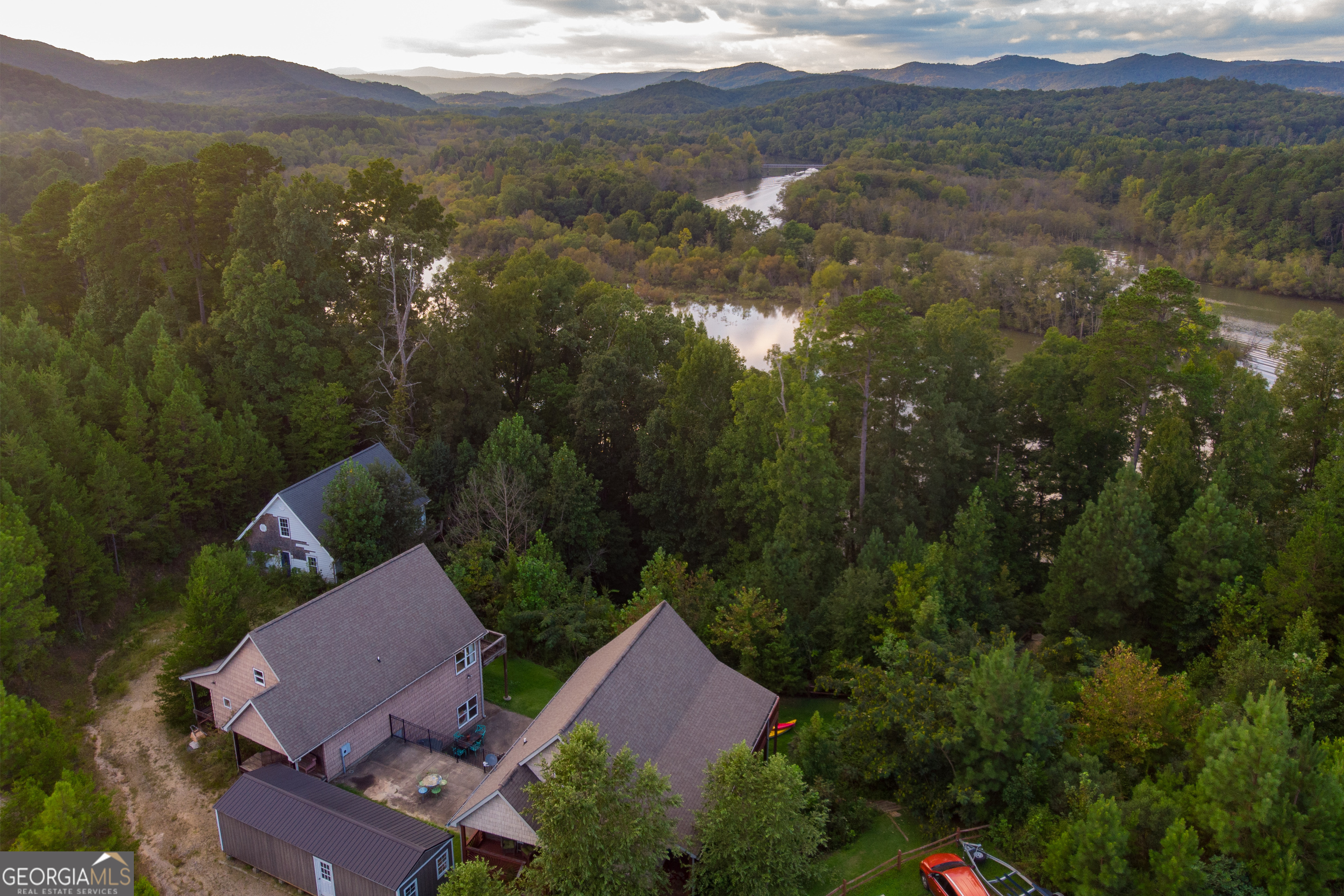 an aerial view of house with yard and mountain view in back