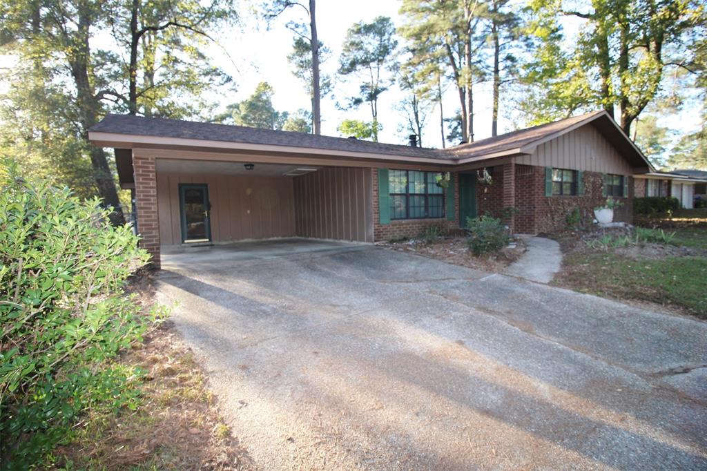 a front view of house with yard and trees in the background