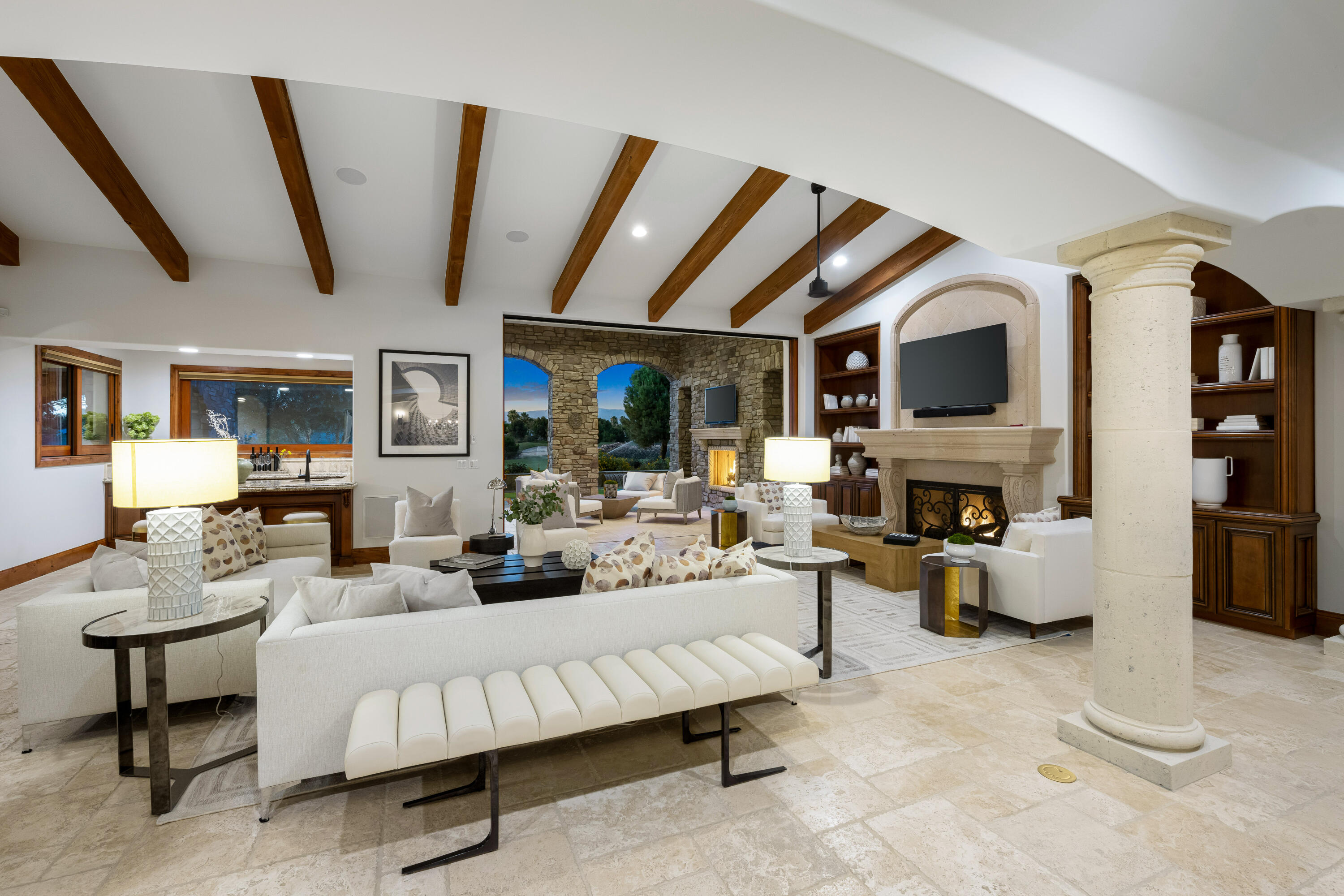 a living room with furniture fireplace and a large window