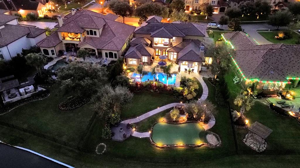 This house is the complete package! Custom lighting is speckled throughout the landscaping to include the illumination down the walk path to the putting green/chipping area and the water.