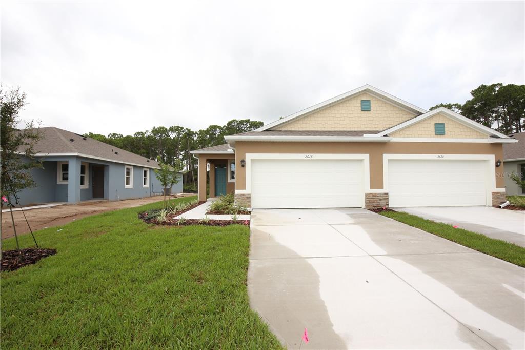 a front view of a house with a yard and garage