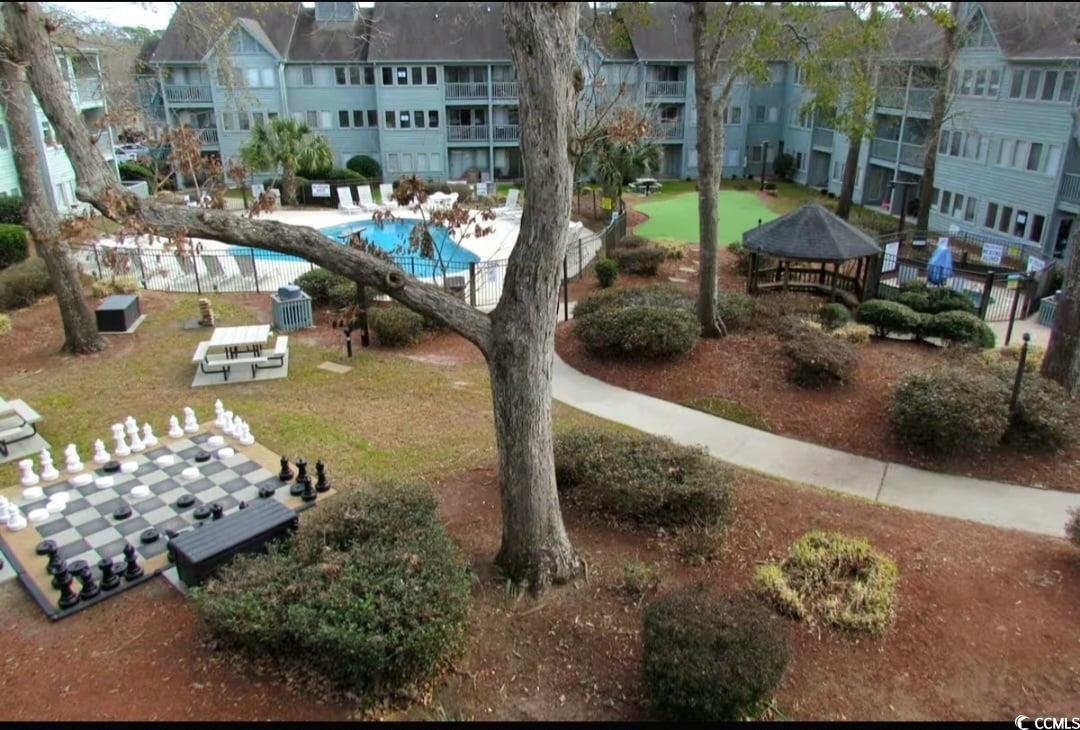 View of home's community with a lawn and a pool