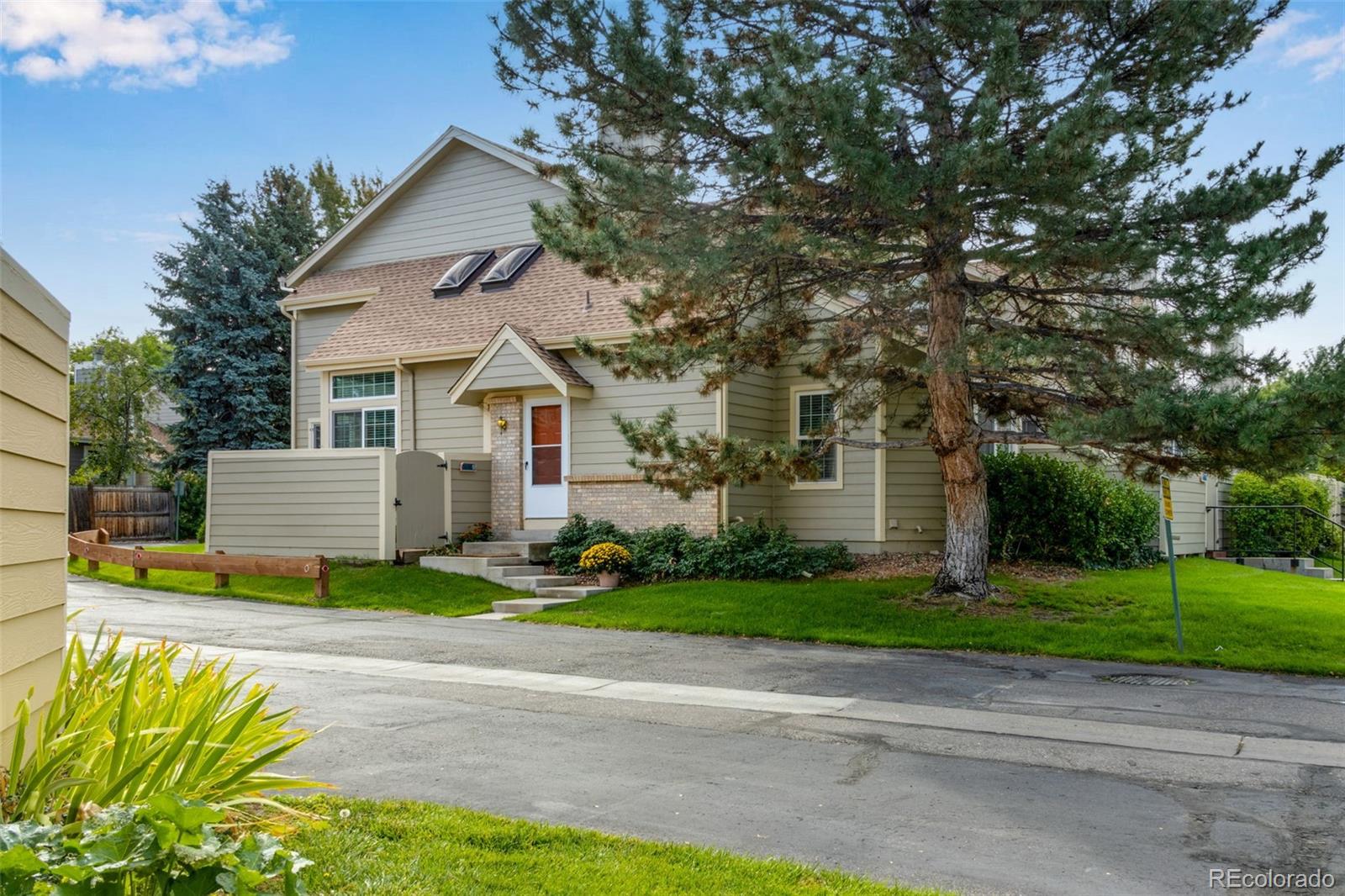 a front view of a house with a yard and trees