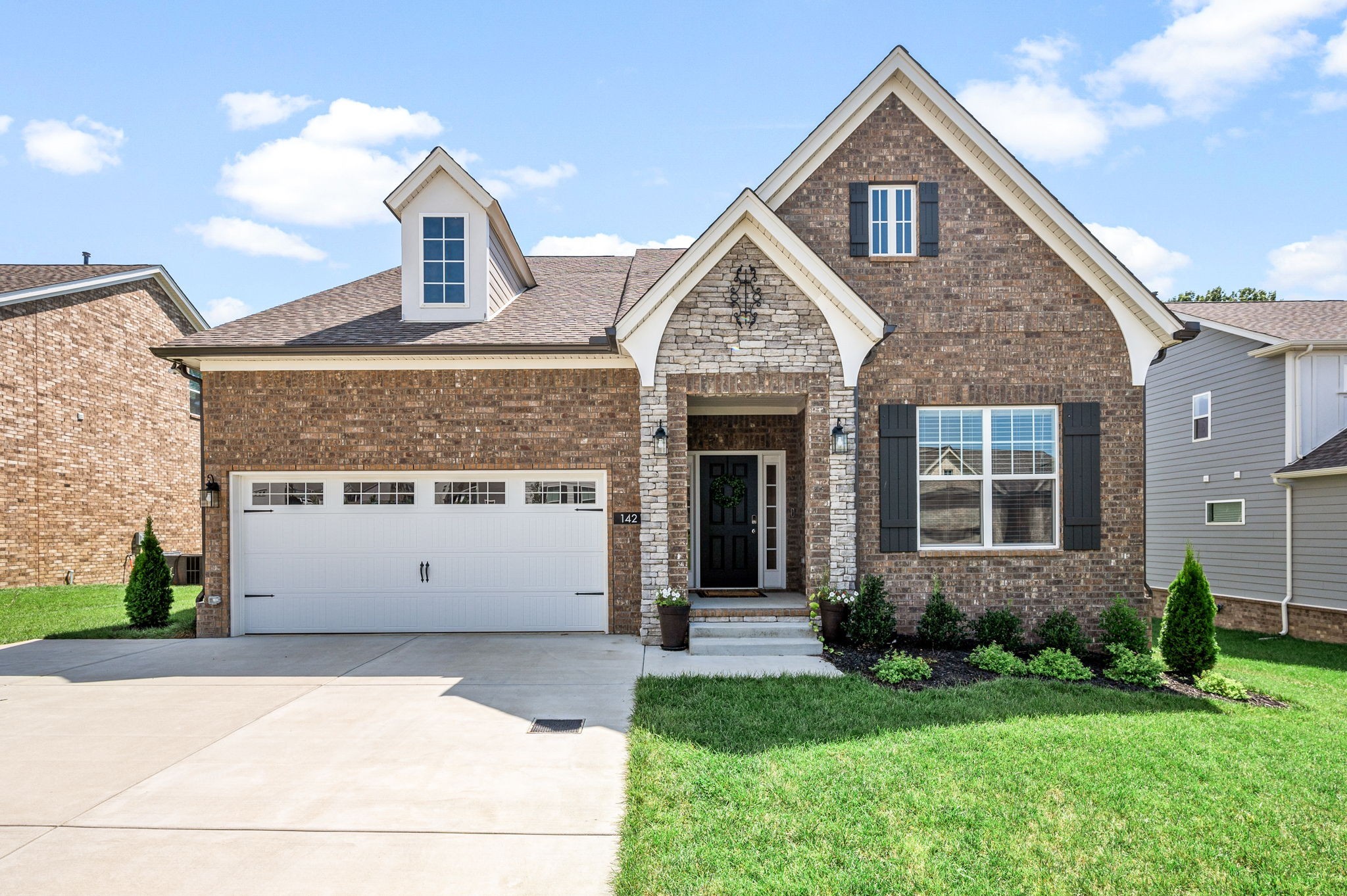 a front view of a house with a yard and garage