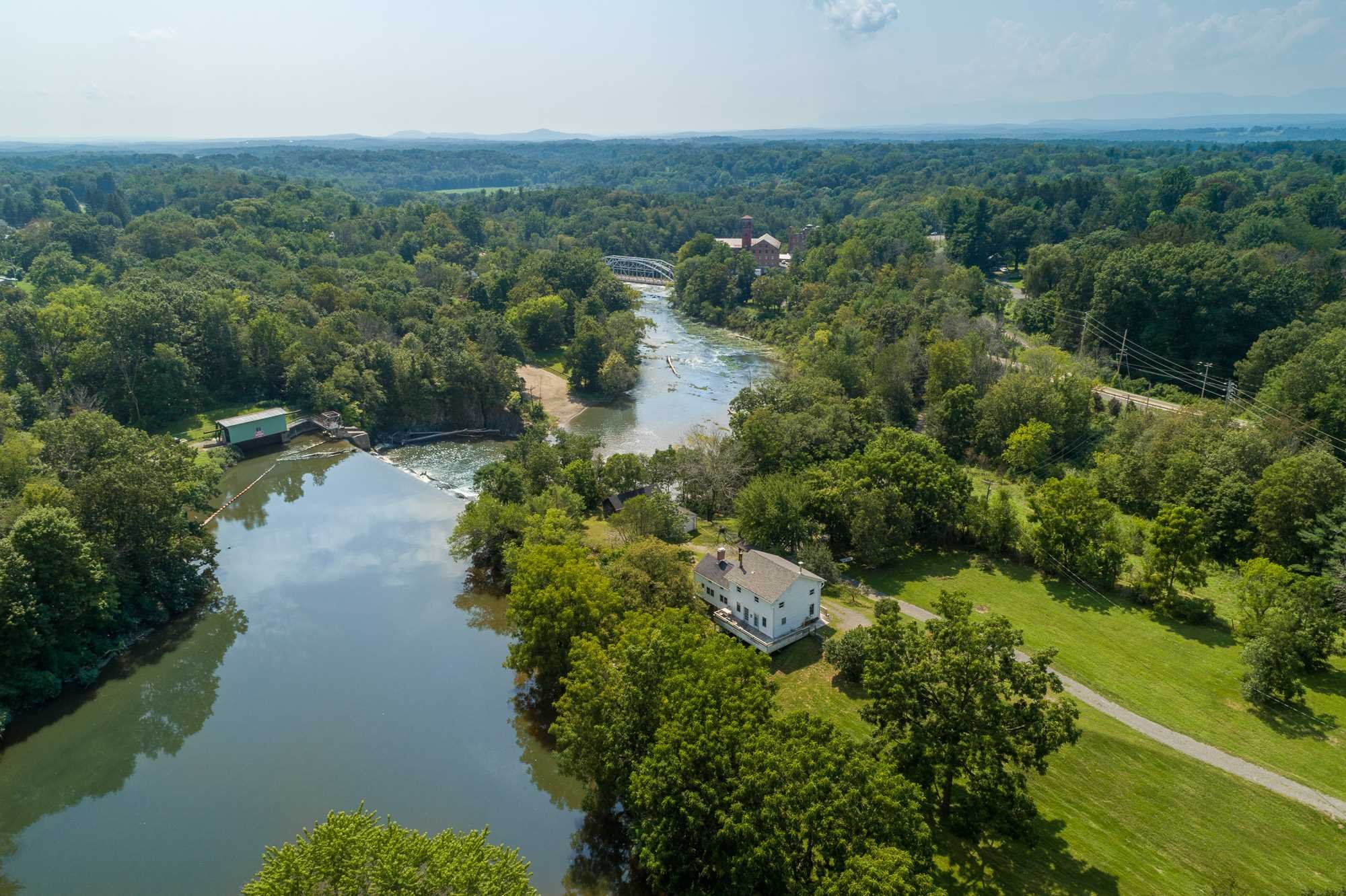 an aerial view of residential house with outdoor space and trees all around