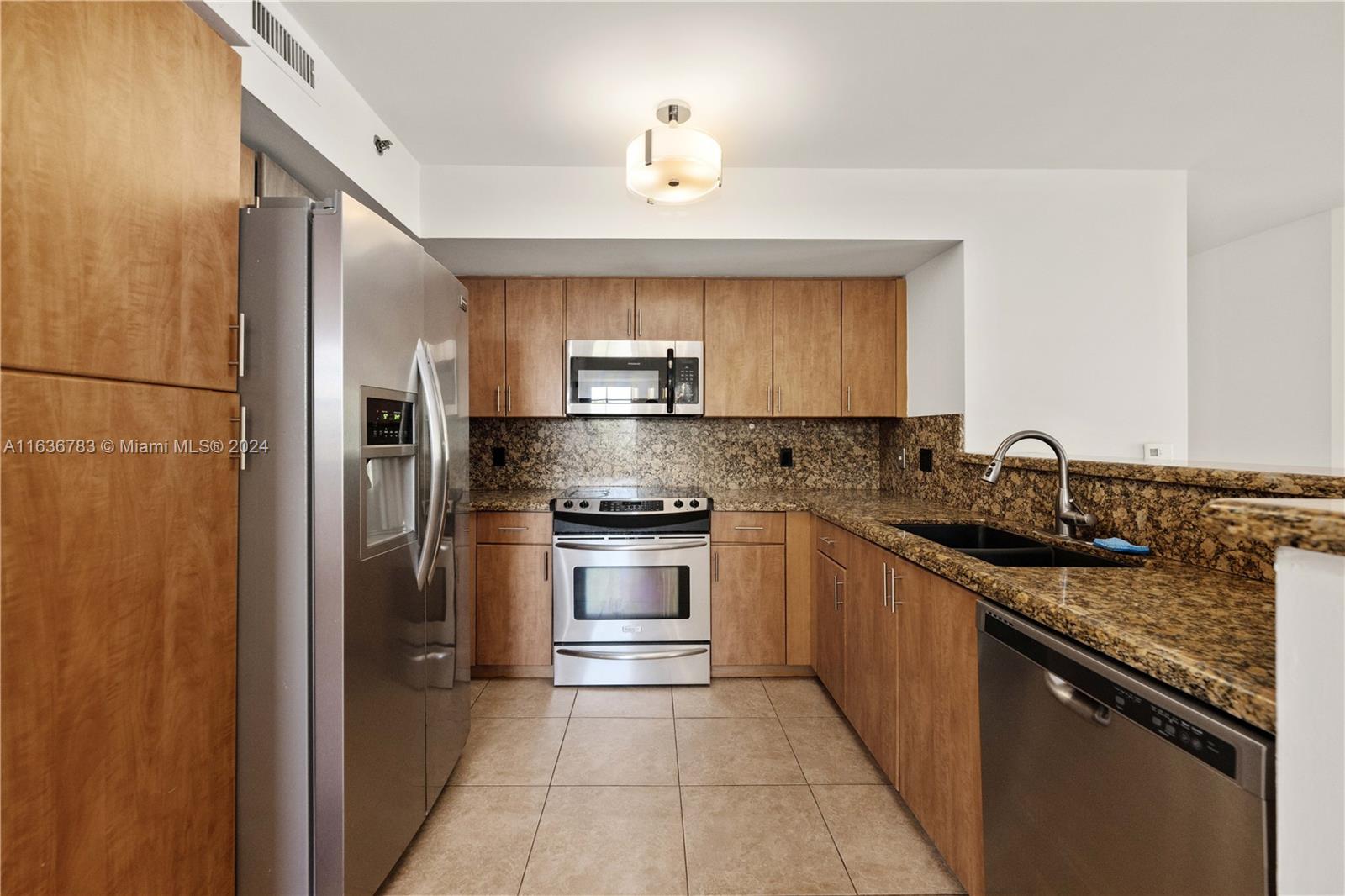 a kitchen with stainless steel appliances granite countertop a sink stove and refrigerator