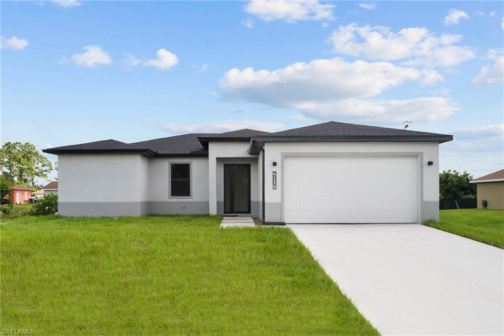 View of front facade with a front yard and a garage