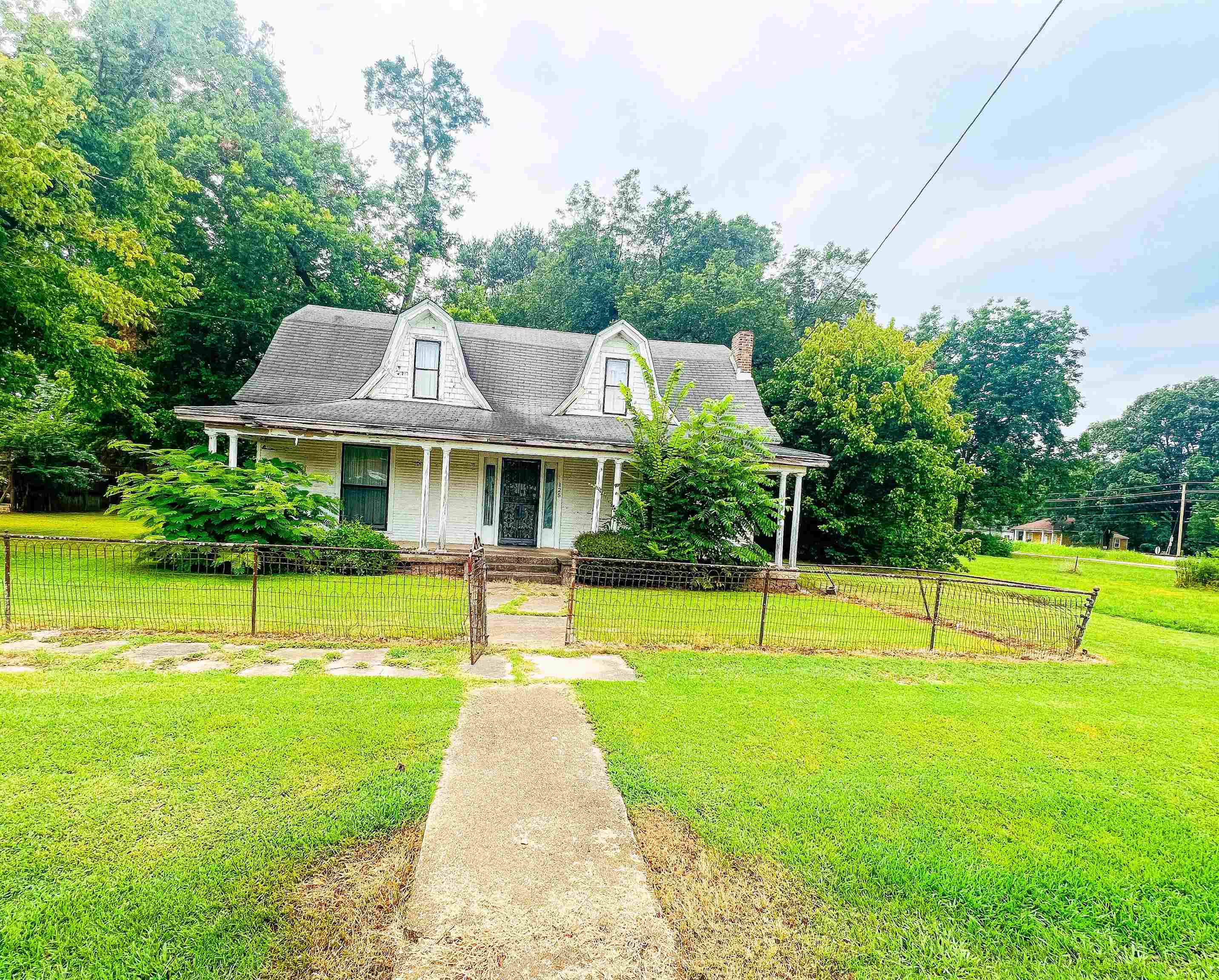 View of front of property featuring a porch and a front yard