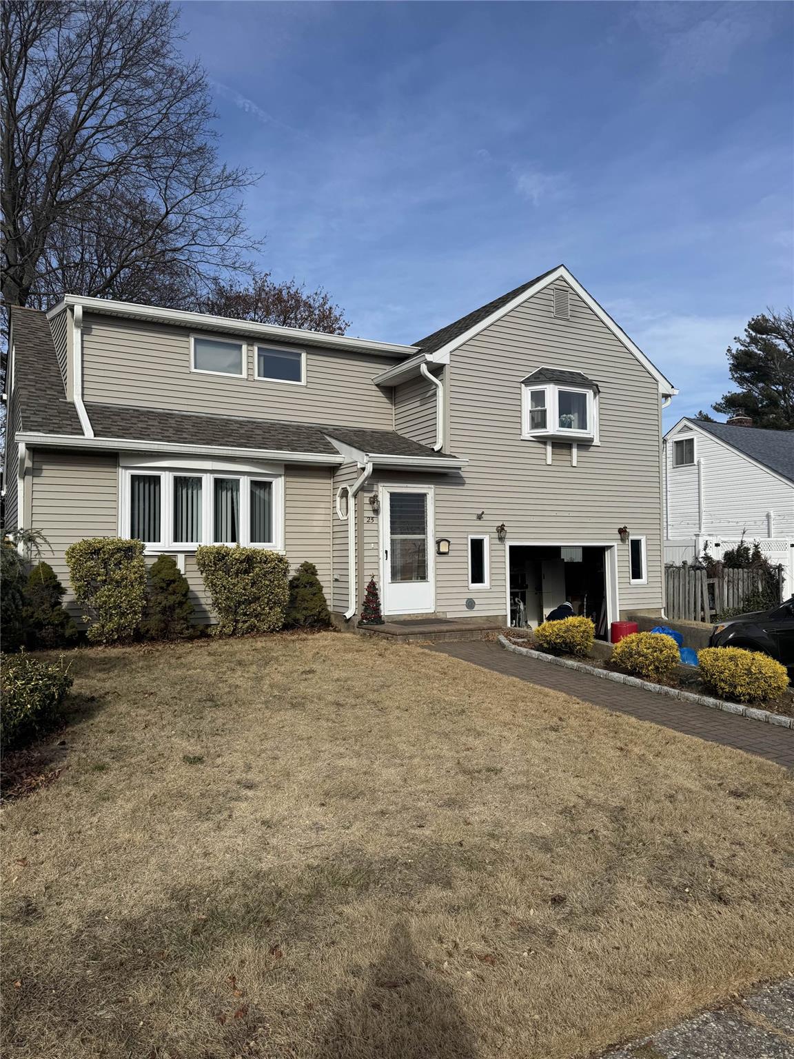 View of front property featuring a garage and a front lawn