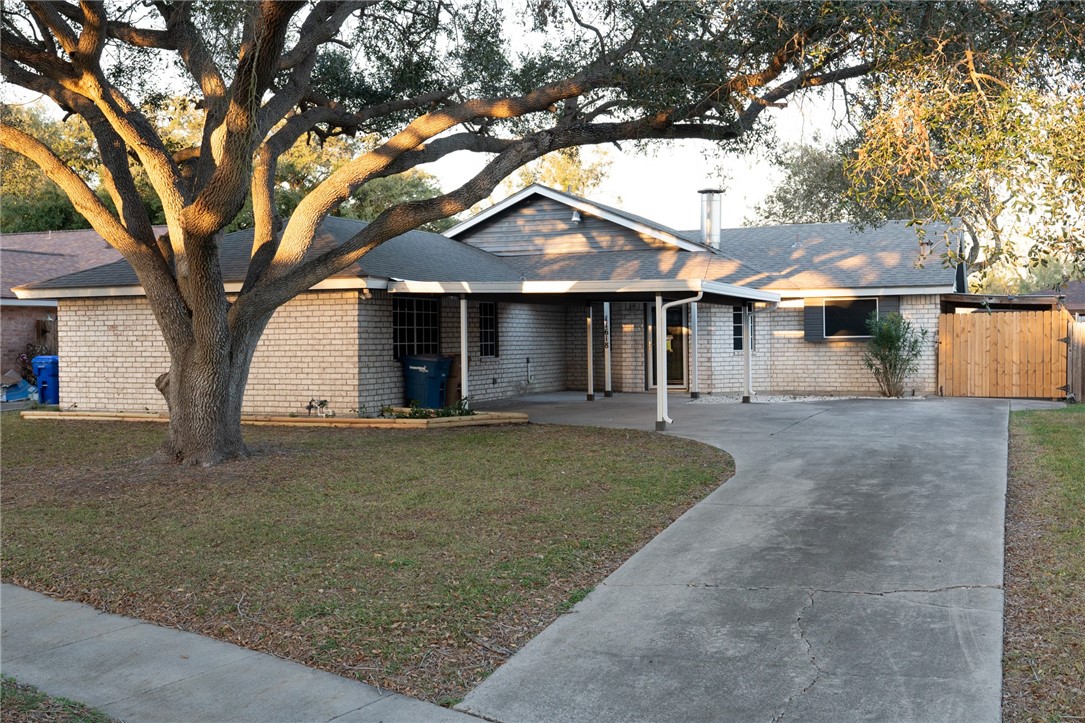 a view of a large house with a tree and a yard