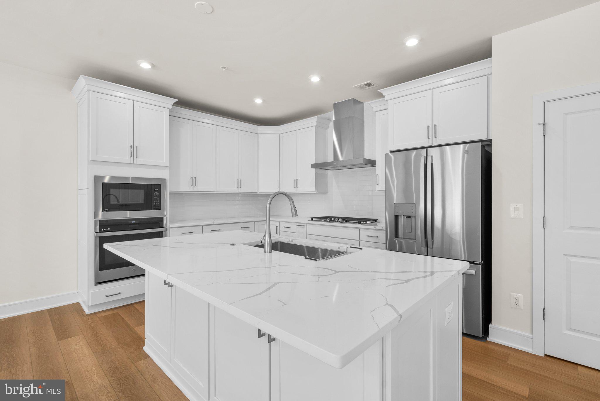 a kitchen with stainless steel appliances a refrigerator sink and microwave