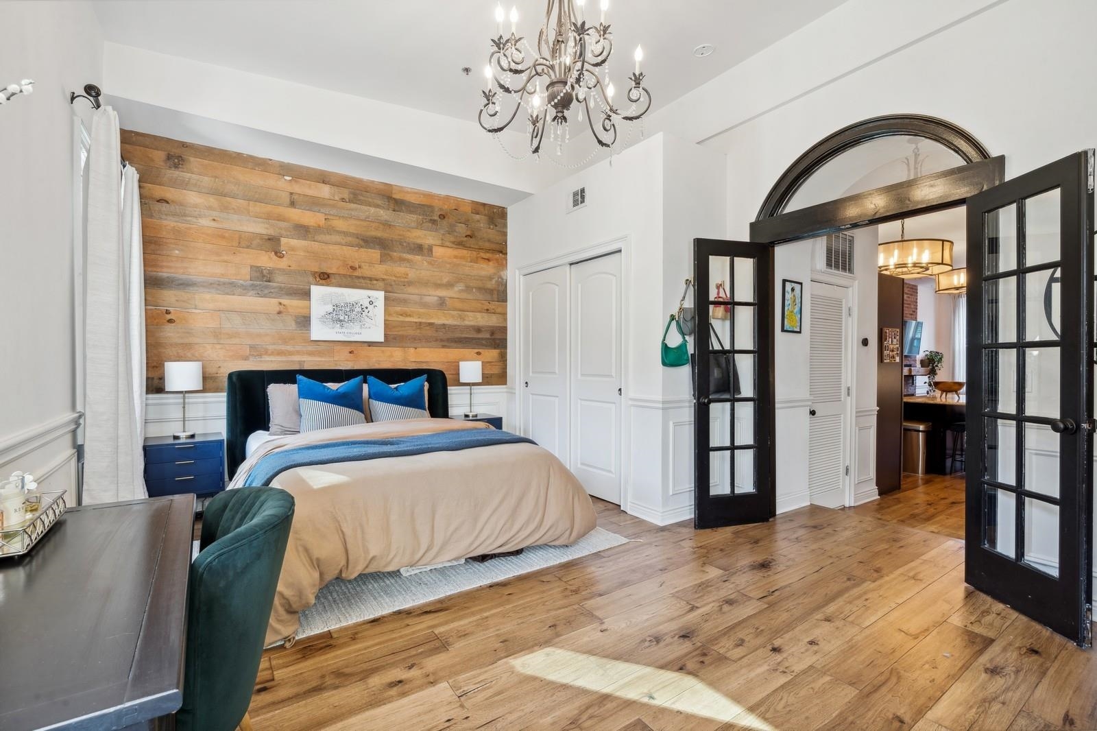 a bedroom with a large bed and a chandelier