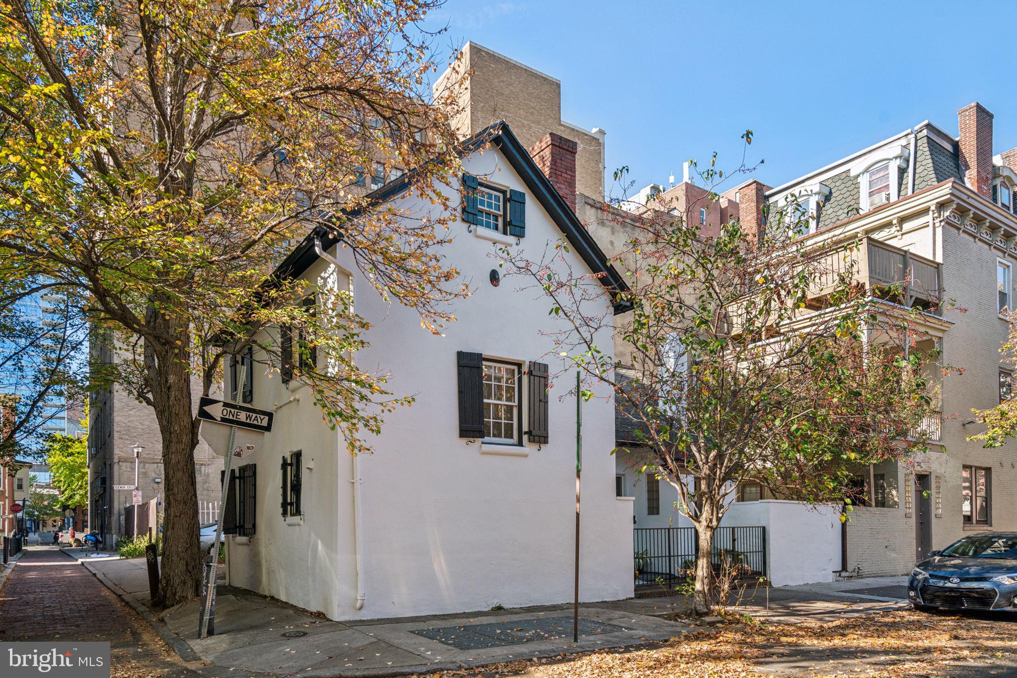 a view of a white house with a large tree