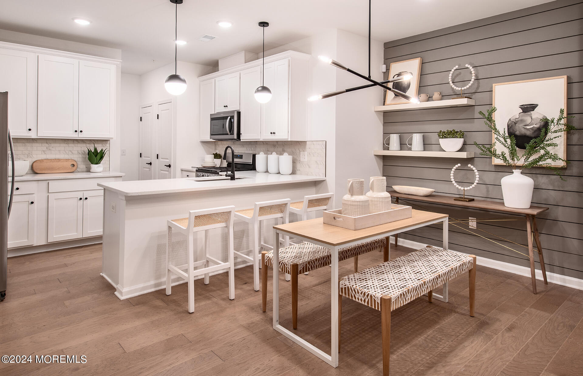 a kitchen with kitchen island a dining table chairs sink and cabinets