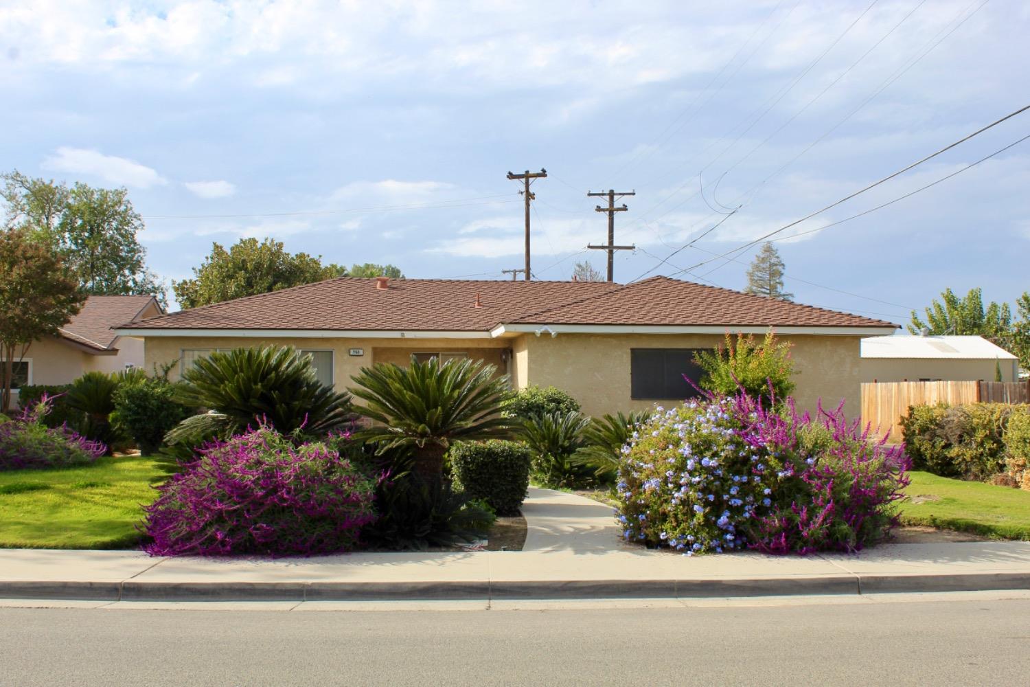 a front view of a house with a yard and potted plants