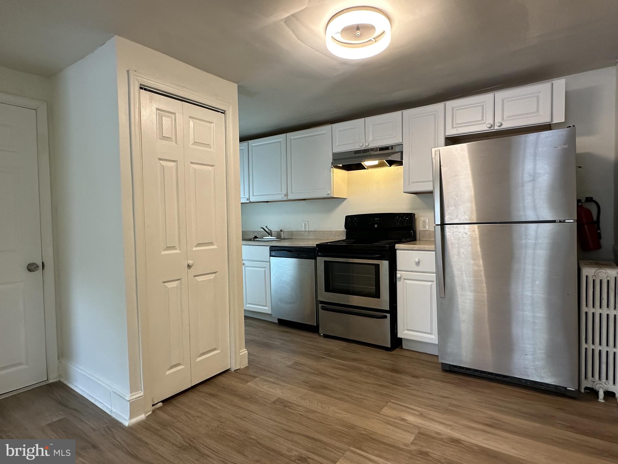 a kitchen with a refrigerator a stove top oven and hallway