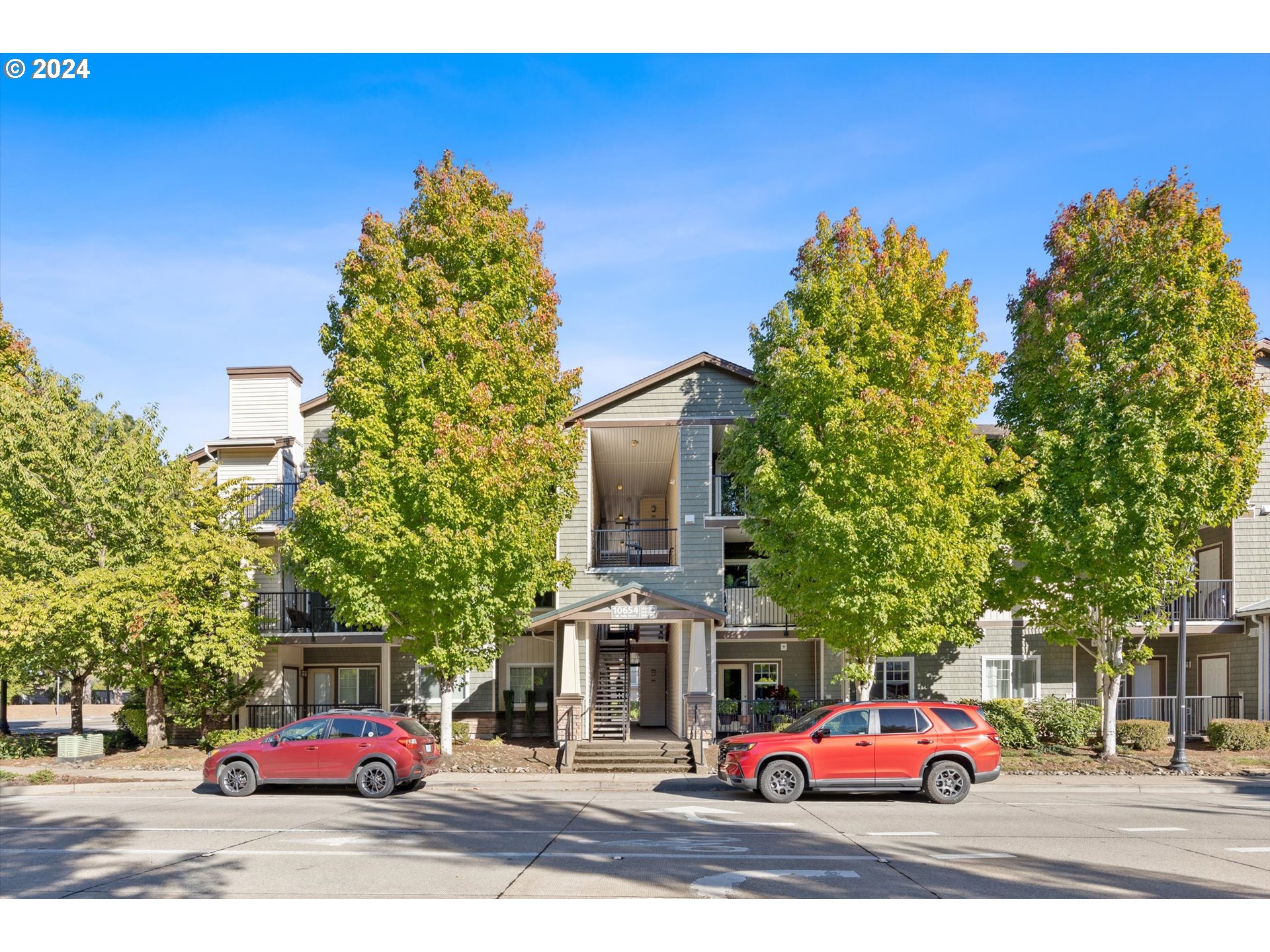 a front view of a building with trees