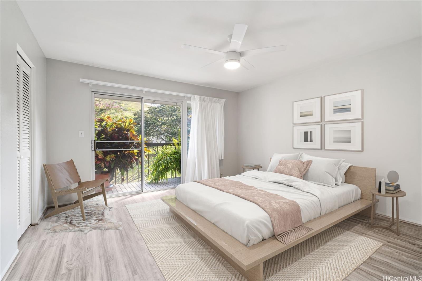 Primary bedroom with private balcony overlooking Plumeria trees.  Virtually Staged.