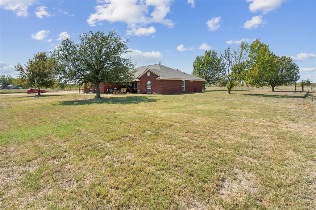 a front view of a house with a yard and trees