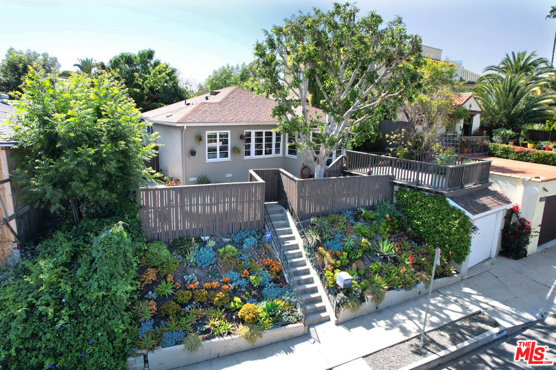 a front view of a house with a yard and potted plants