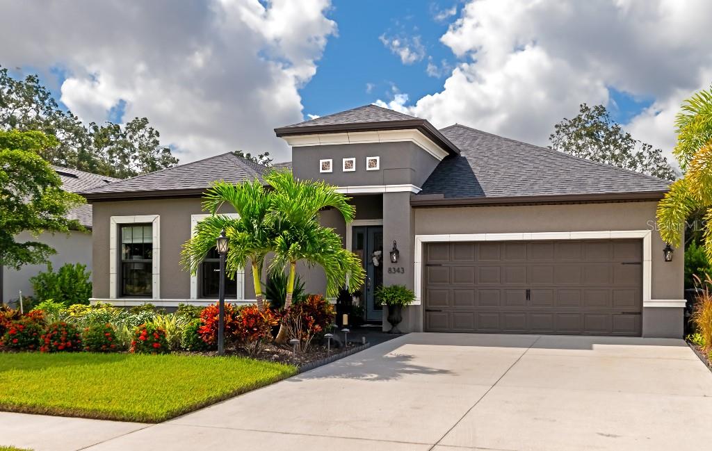 a front view of a house with a garden and garage