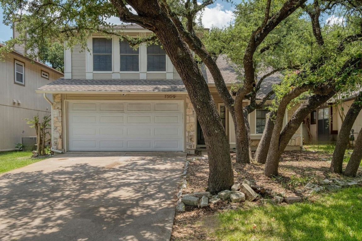 a front view of a house with a yard and garage