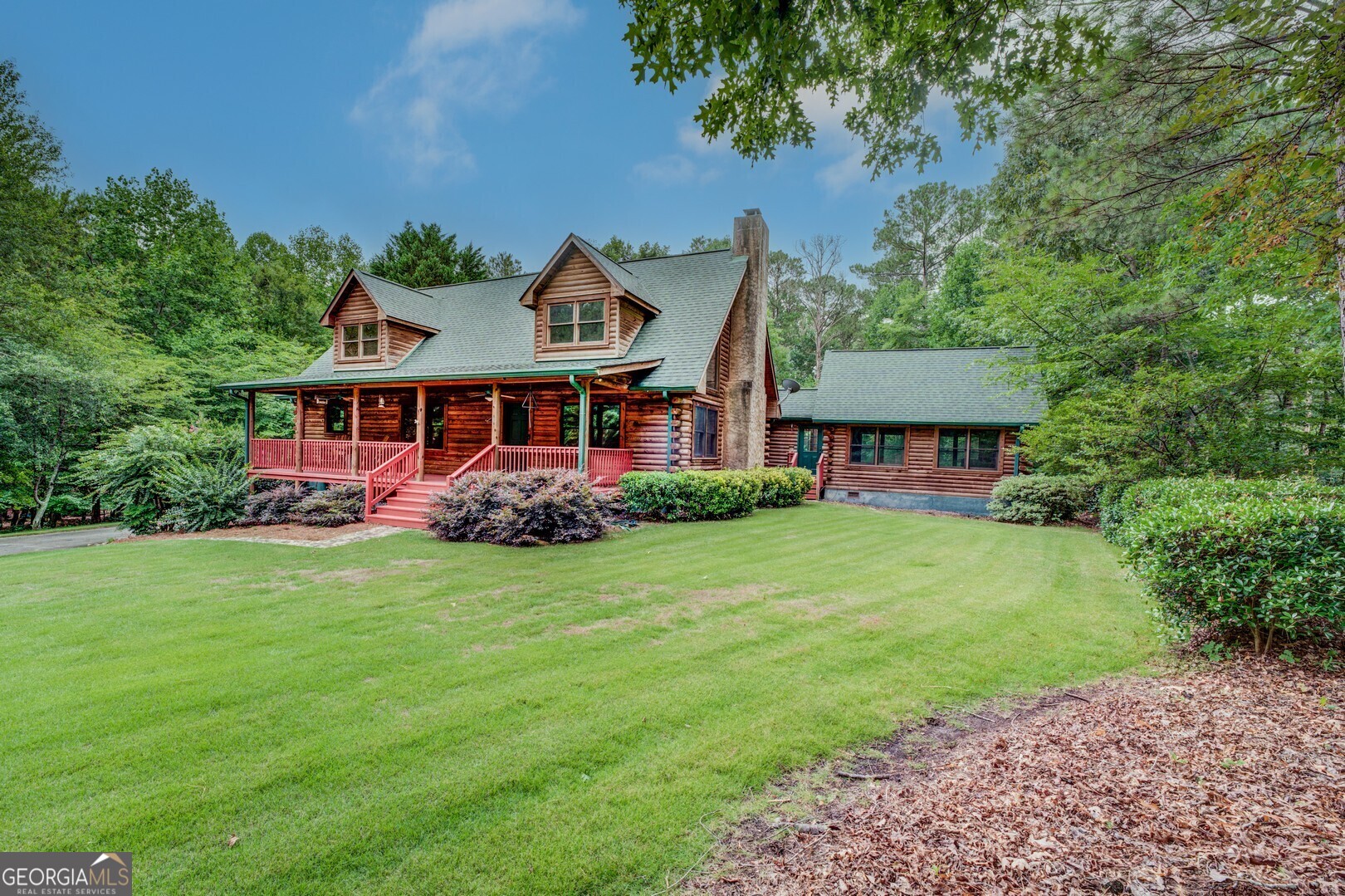 a front view of a house with a garden and trees