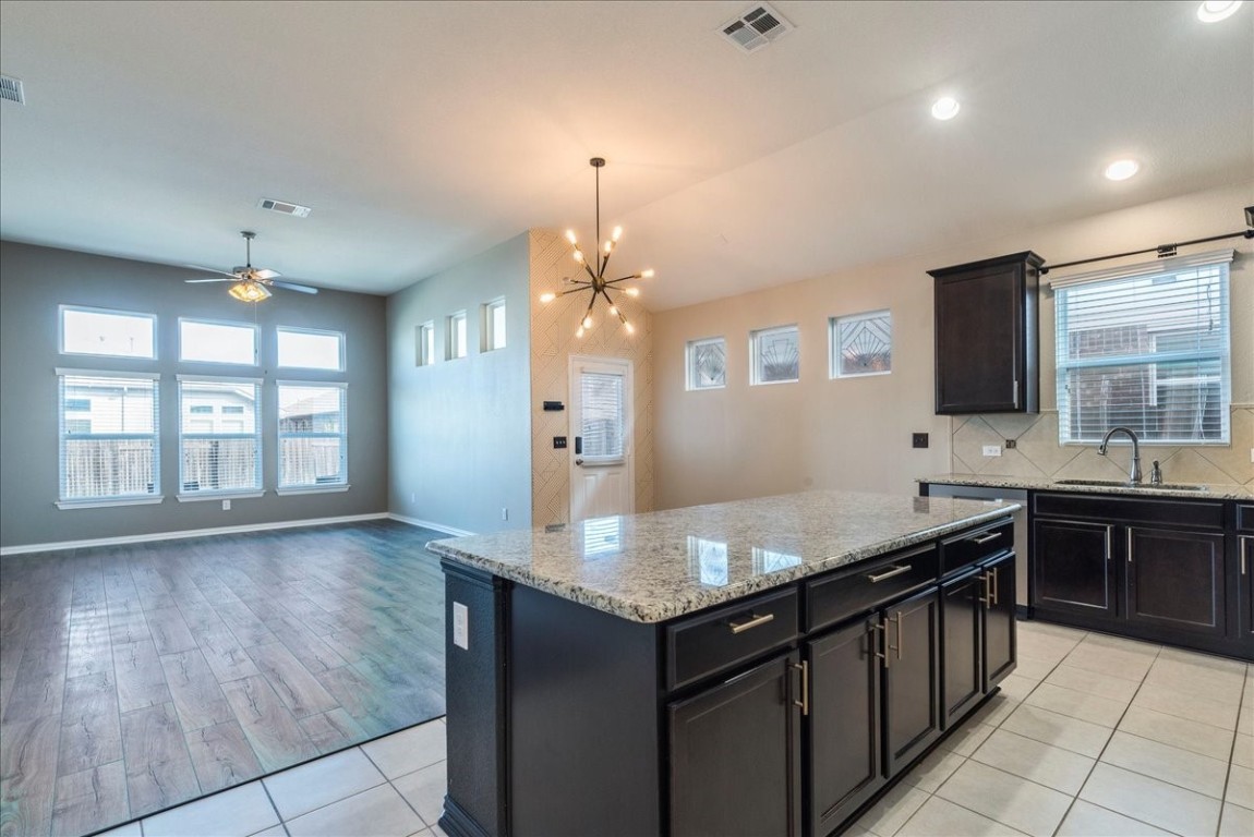 a kitchen with granite countertop a sink counter top space cabinets and stainless steel appliances