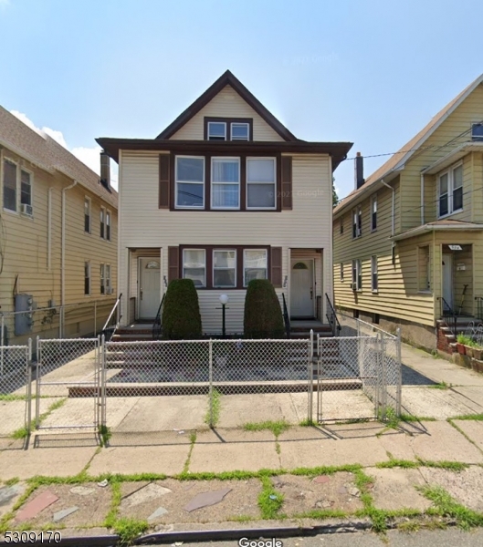 a view of a brick house with large windows next to a road