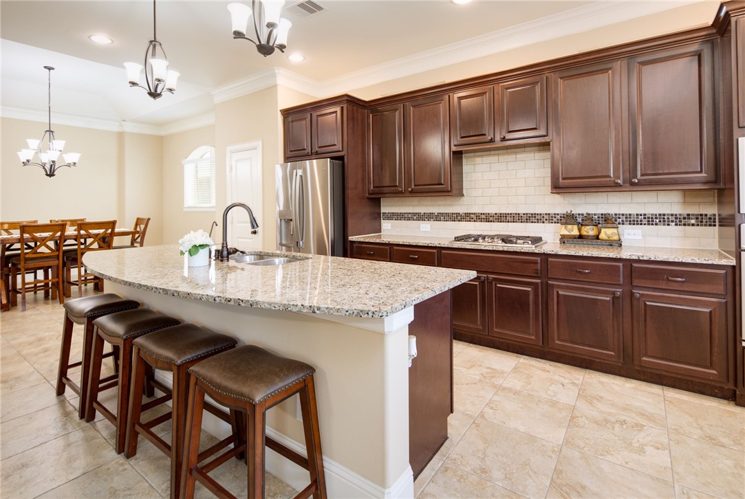 Kitchen featuring sink, an island with sink, appli