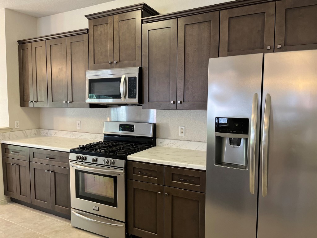 a kitchen with a refrigerator stove and microwave