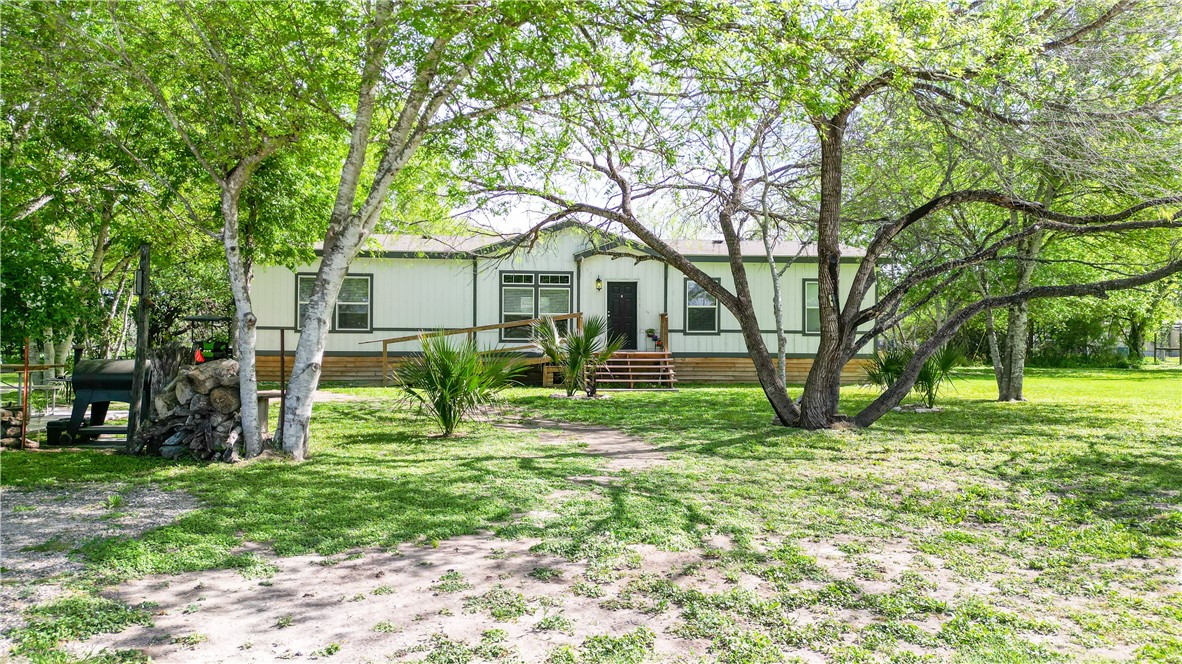 a view of backyard of house with green space