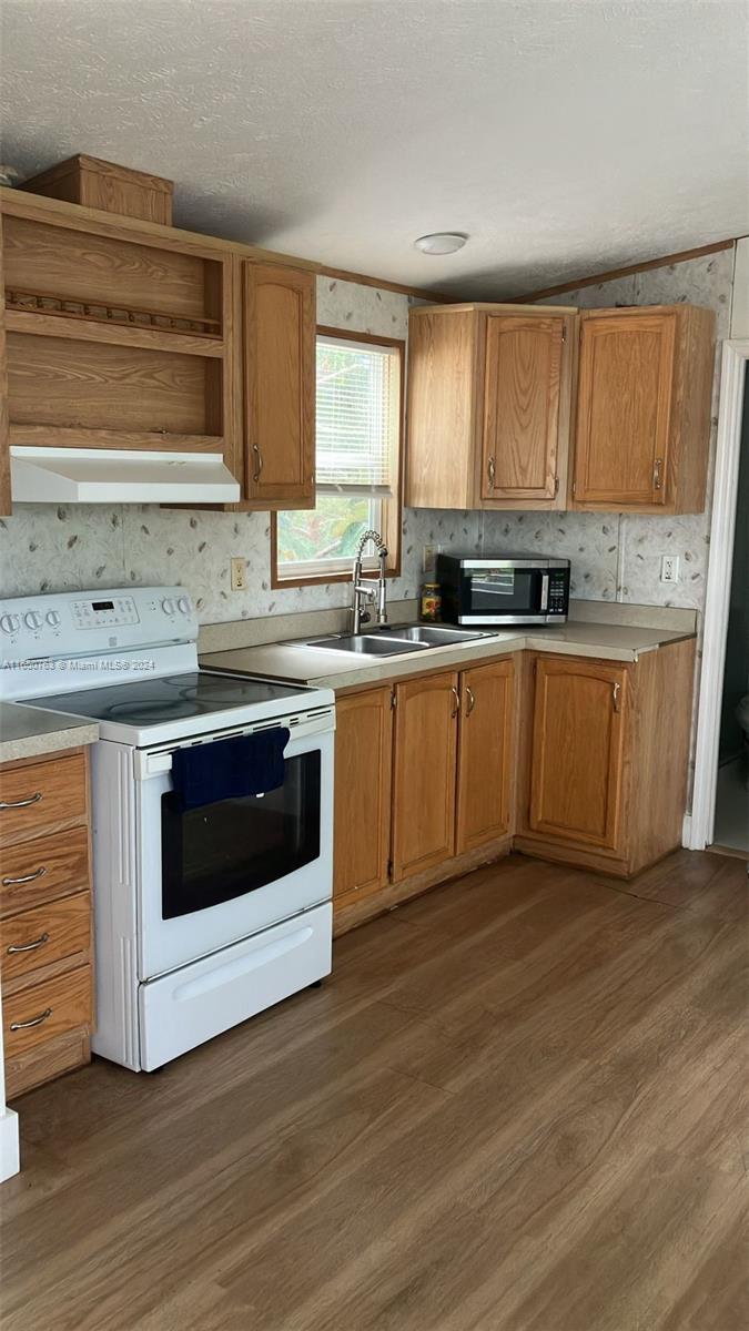 a kitchen with stainless steel appliances granite countertop a stove a sink and a microwave