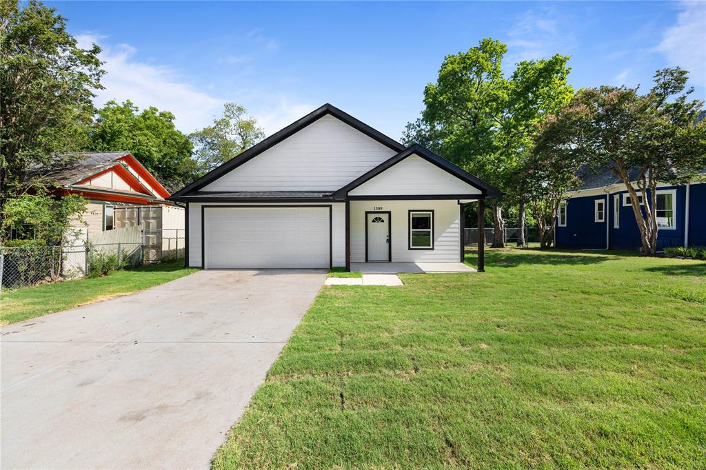 a front view of a house with a yard and trees