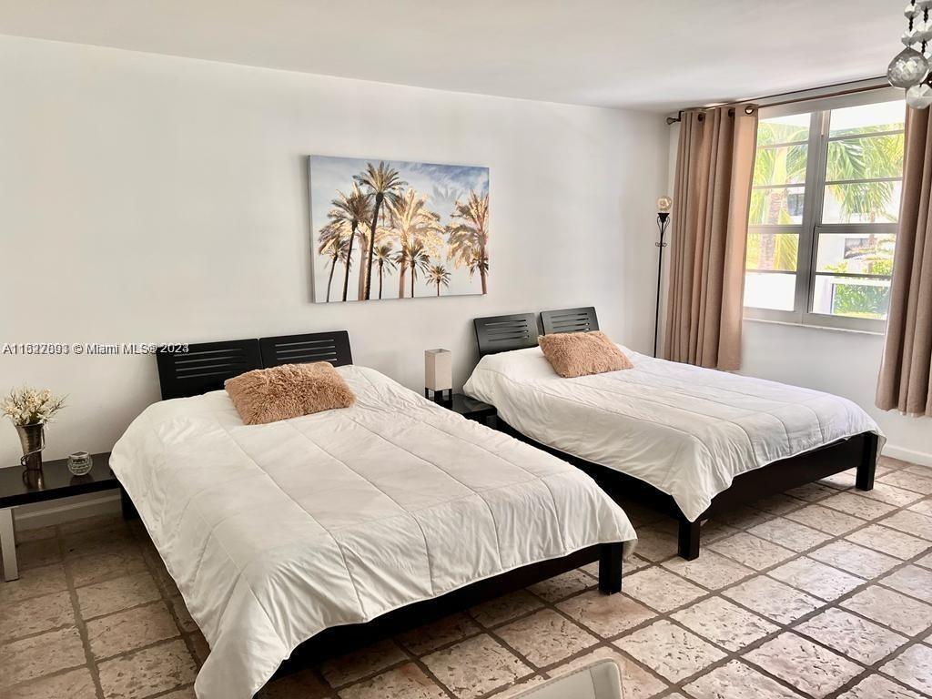 a bedroom with two beds and a large window