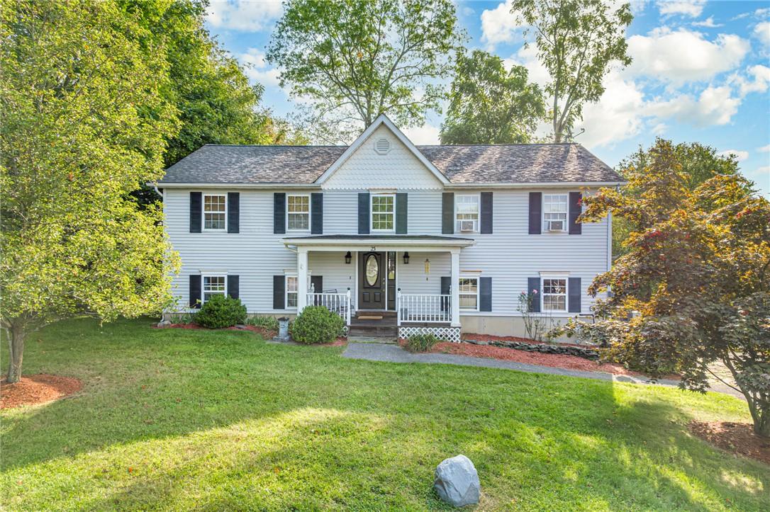 Home with covered porch and a front yard