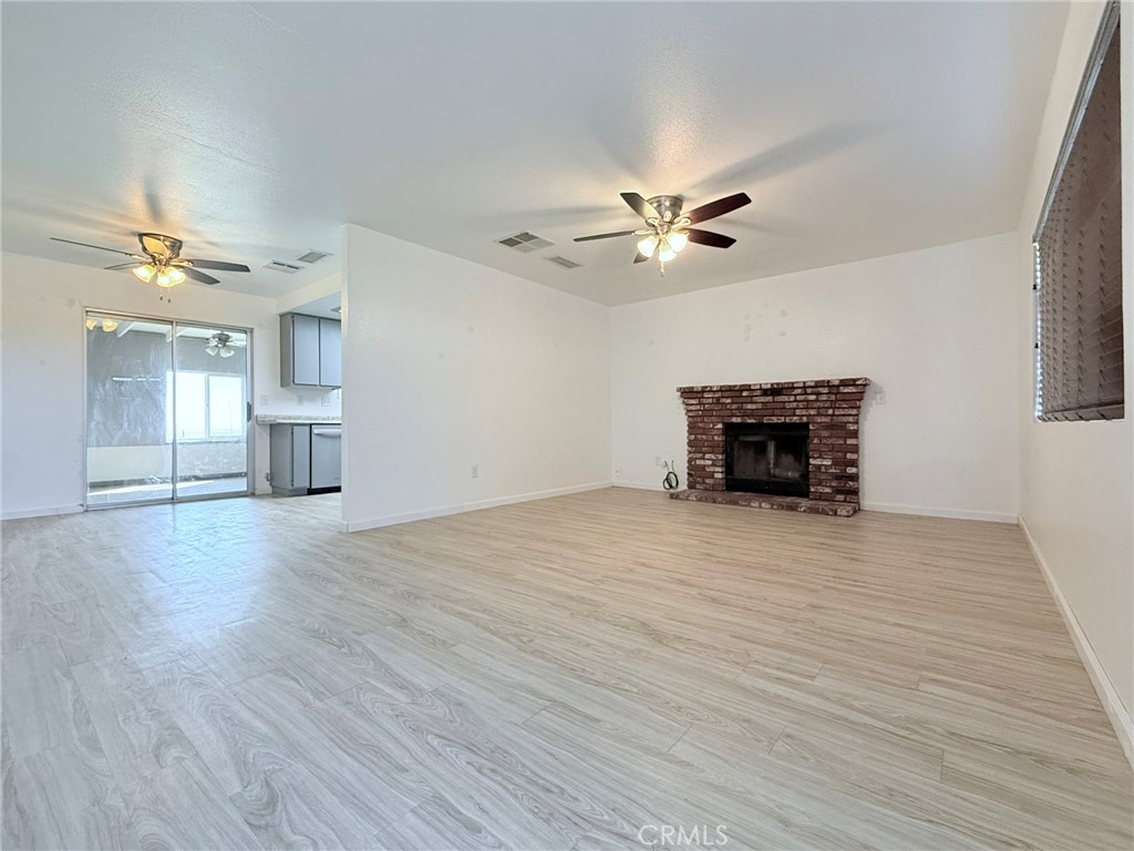 a view of empty room with a fireplace and wooden floor