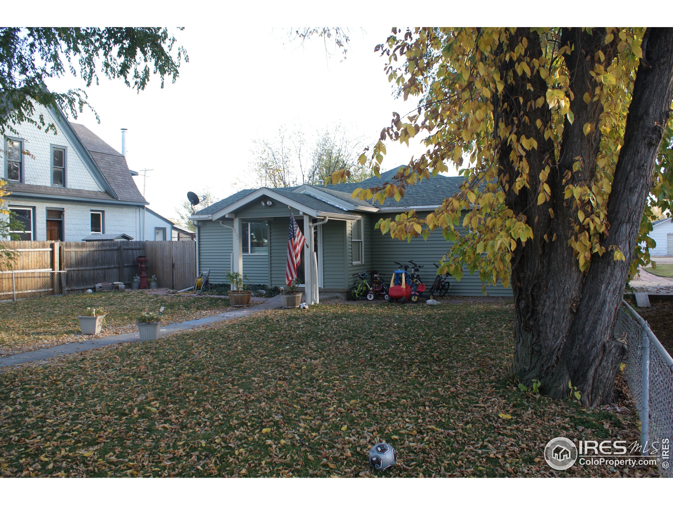 a front view of a house with a yard and trees