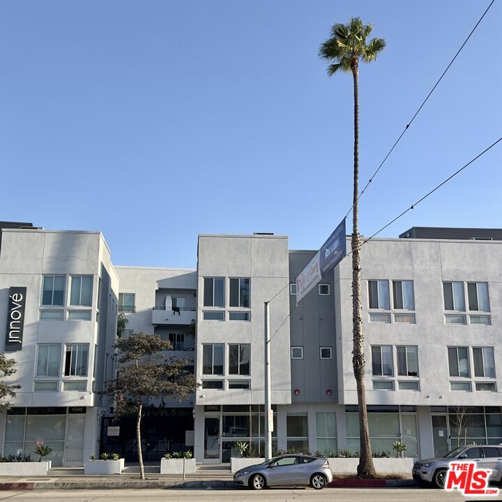 a front view of a building with streets and trees