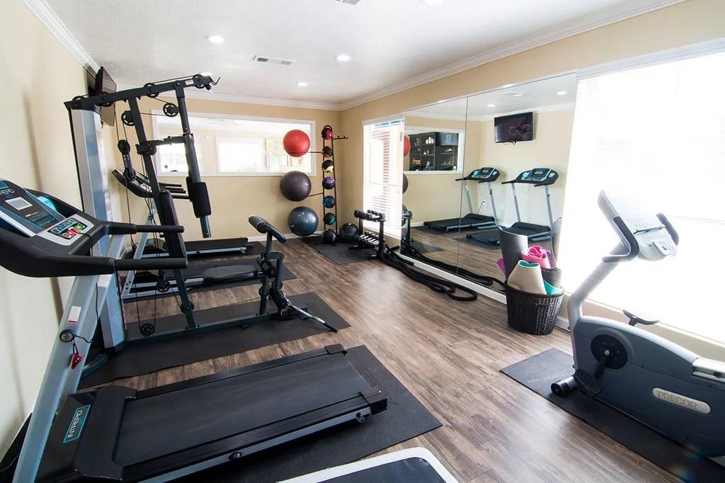 a living room with furniture gym equipment and a wooden floor