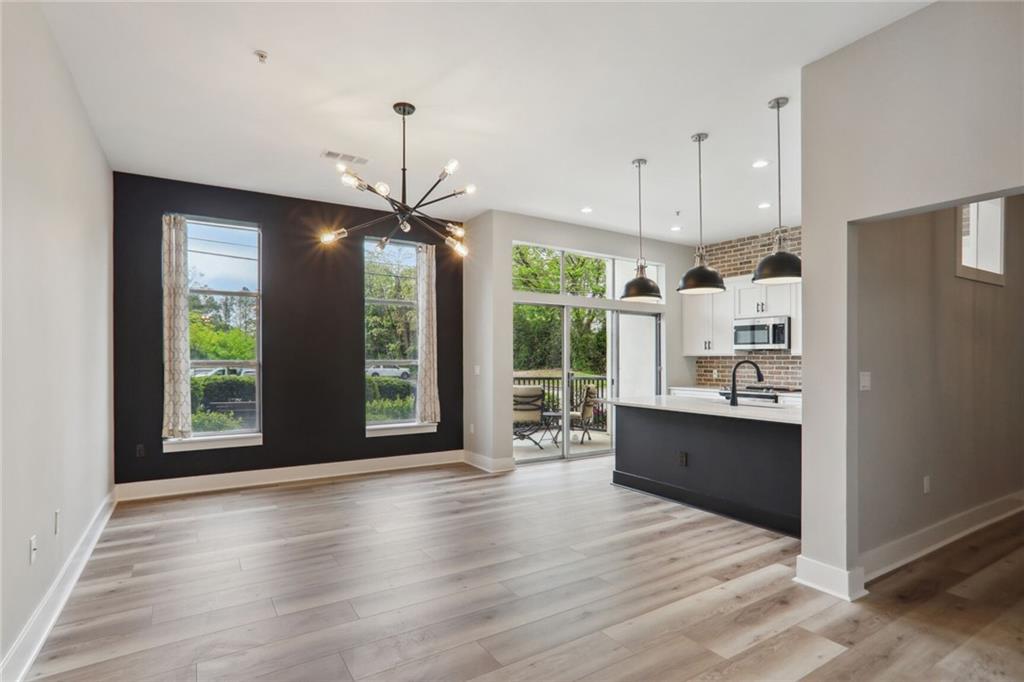 a view of kitchen with granite countertop a stove top oven a sink with wooden floor and cabinets