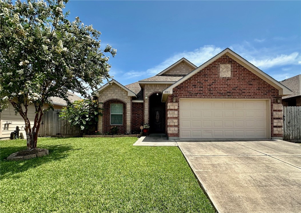 a front view of a house with yard and garage