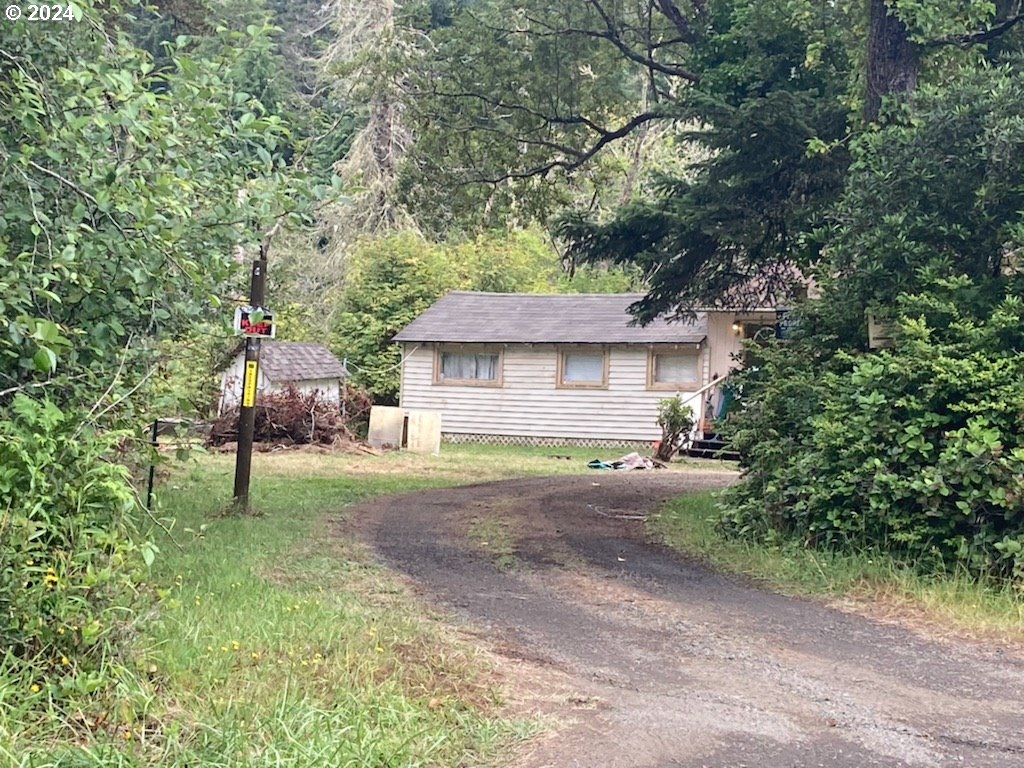 a view of a house with backyard and a tree