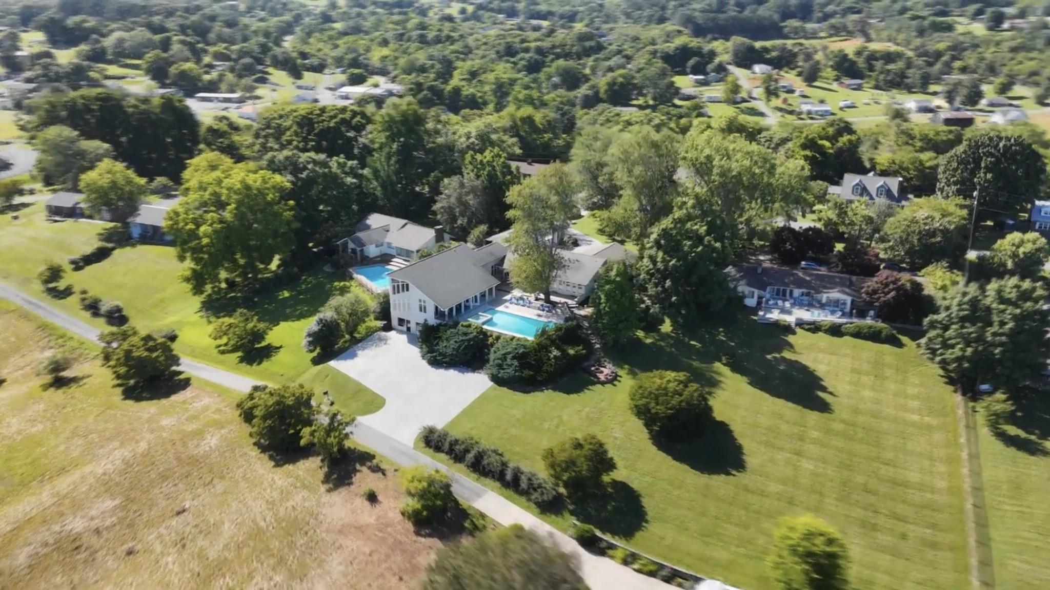 an aerial view of residential houses with yard and swimming pool