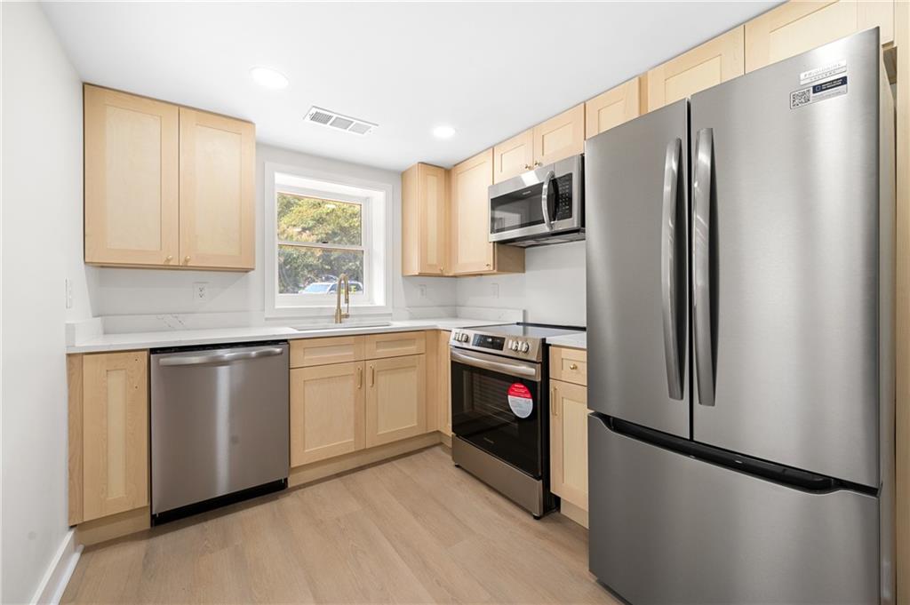 a kitchen with stainless steel appliances granite countertop a refrigerator sink and microwave