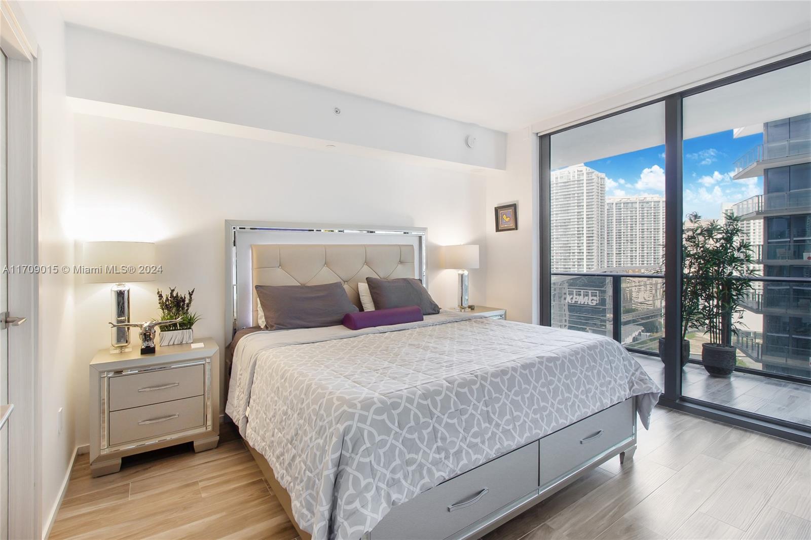 a bedroom with a large bed and wooden floor