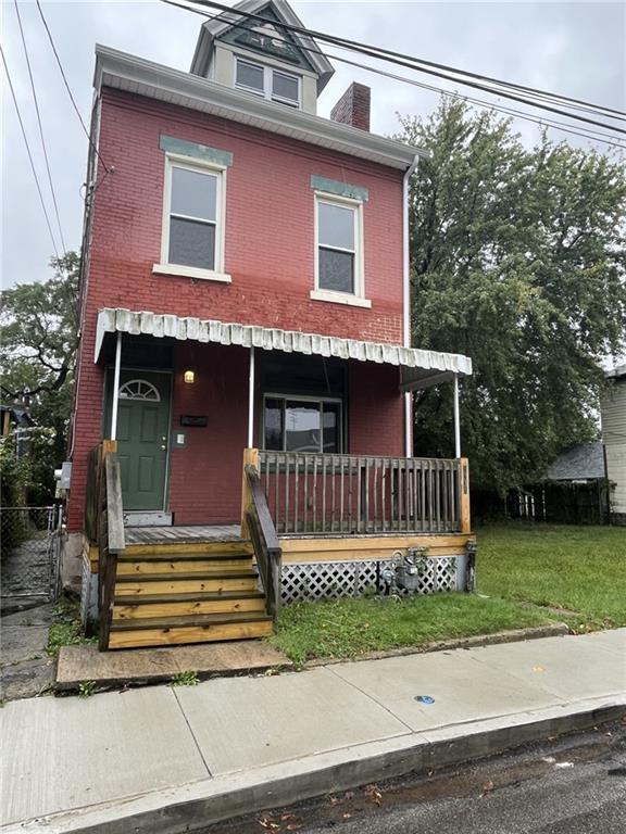 a view of a house with a small yard and wooden floor and fence